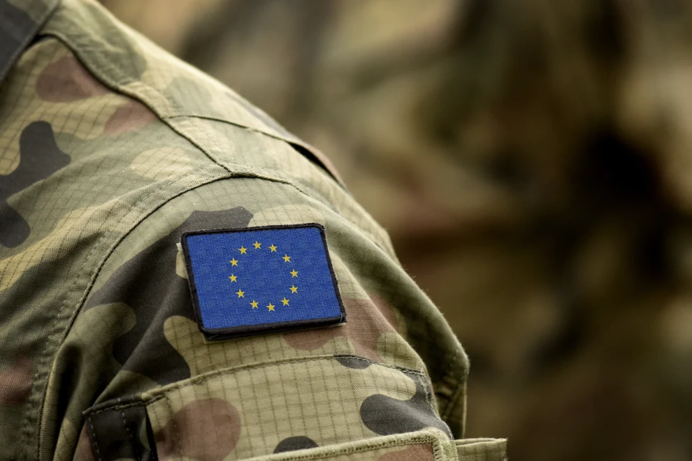 Axel på person i militärkläder med broderad EU-flagga.