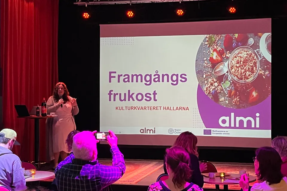 En grupp människor som sitter framför en projektionsduk.
